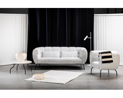 Minimalistisch-modernes Wohnzimmer mit dem weißen Sofa Magnolia, einem passenden Sessel und einem Tisch mit stilvollen schwarz-weißen Akzenten.