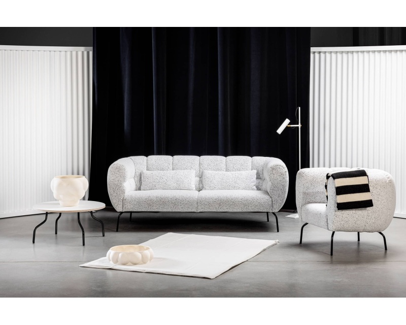 Minimalistisch-modernes Wohnzimmer mit dem weißen Sofa Magnolia, einem passenden Sessel und einem Tisch mit stilvollen schwarz-weißen Akzenten.