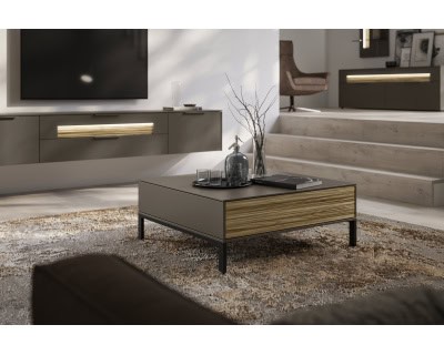 Modernes Wohnzimmer in neutralen Farbtönen, mit dem eleganten Couchtisch SALE 25 Wohnkombination Linee, TV-Set und gemütlicher Sitzecke.